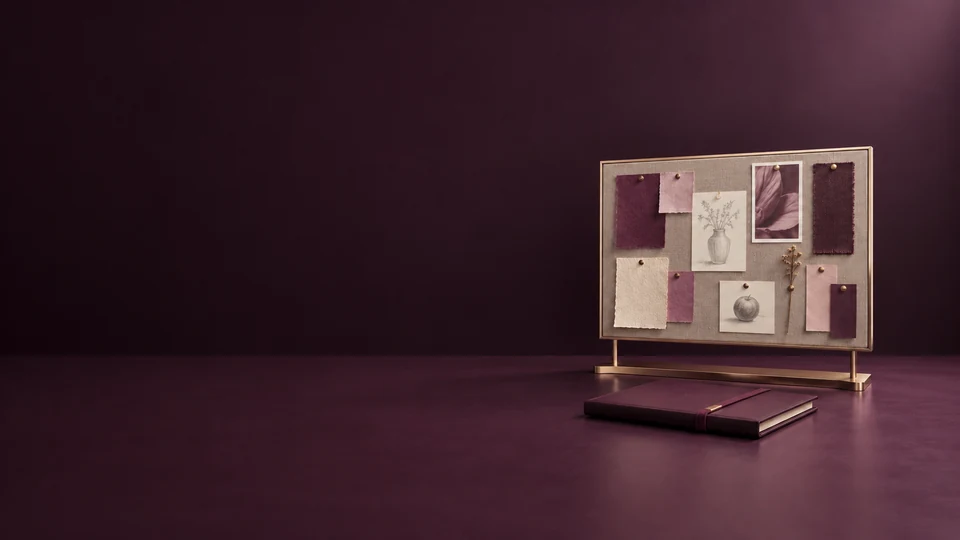 A studio pinboard with paper samples and pencil studies above a closed plum folio. - Arts Design & Creative Services Meta ads research index