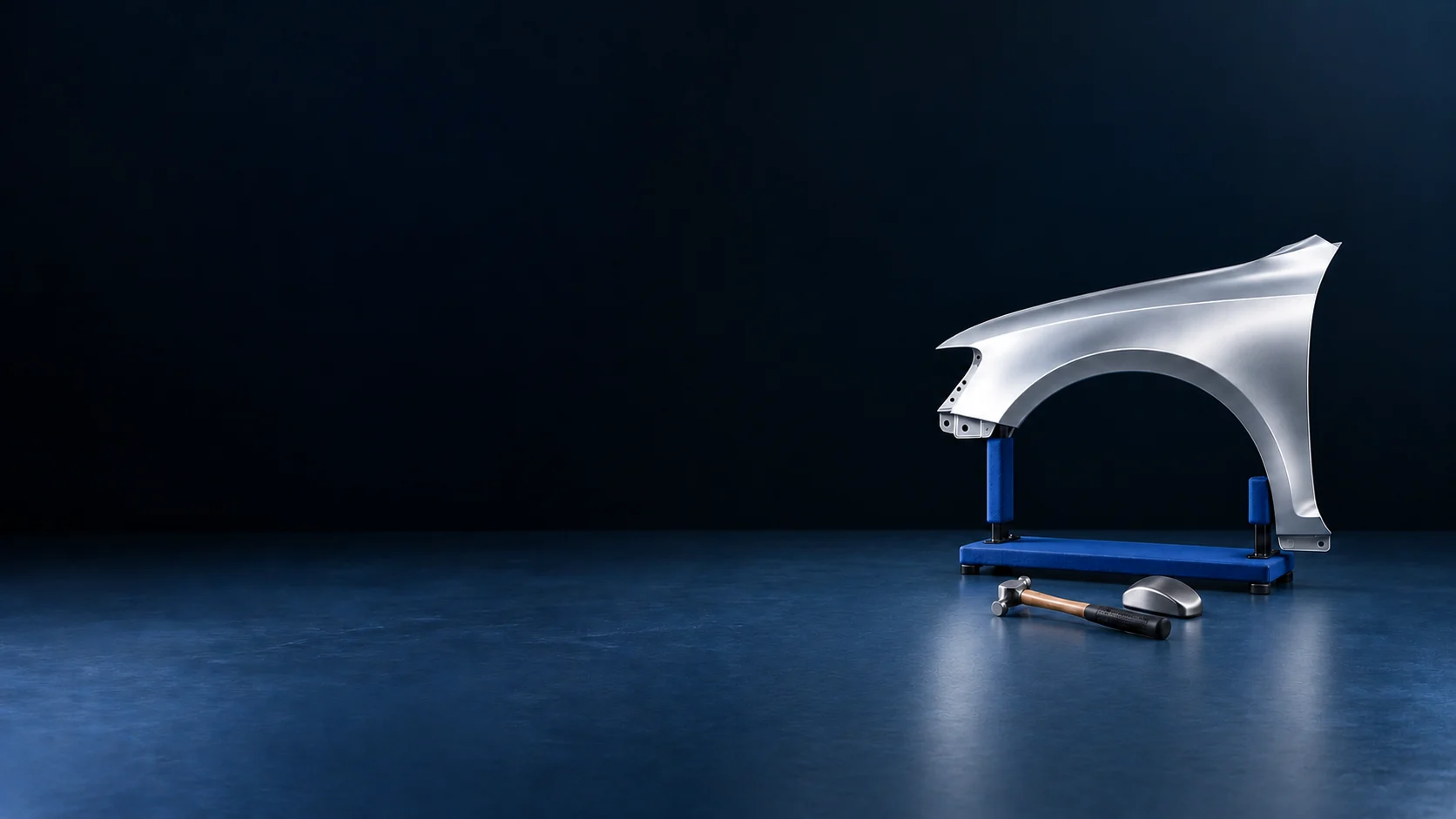 A complete silver automotive fender on a padded blue stand, with a bodywork hammer and steel dolly. - Body & Collision Repair Meta ads research by Madgicx Labs