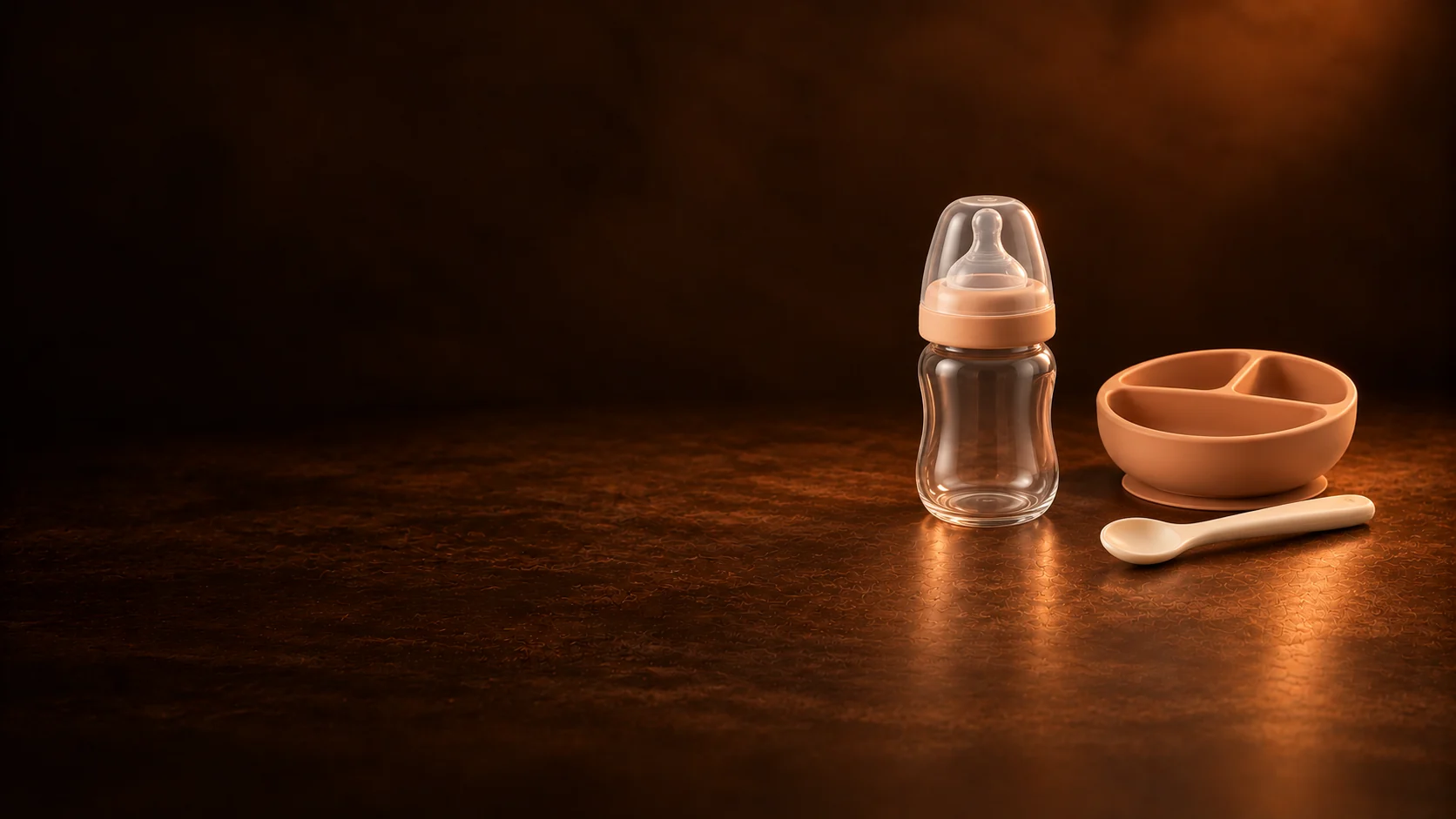 An empty clear baby bottle beside a terracotta divided bowl and a small spoon. - Feeding & Nutrition Products Meta ads research by Madgicx Labs