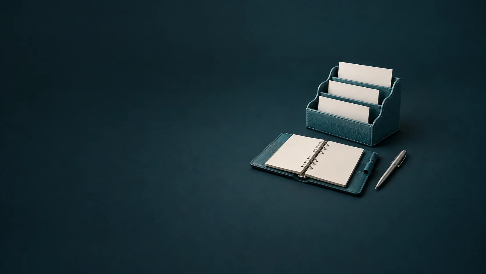 A teal leather correspondence organizer with blank task cards beside an open ring planner and silver pen. - Administrative Support Services Meta ads research by Madgicx Labs
