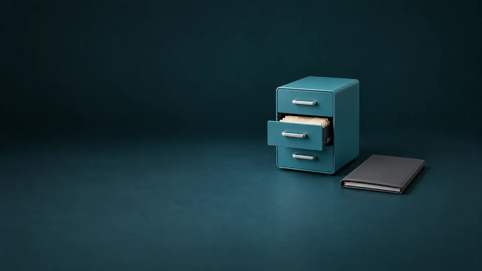 A teal three-drawer filing console with blank tabbed folders in its open middle drawer beside a graphite folio. - Business Process Outsourcing Meta ads research index