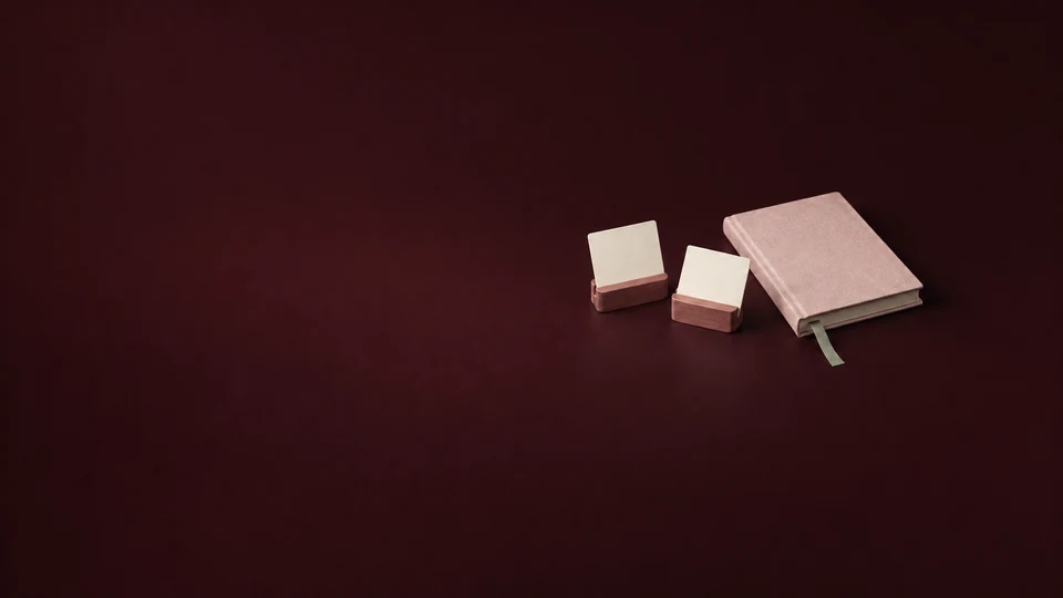 Two blank cards in rosewood holders beside a petal journal and sage bookmark. - Dating & Relationship Services Meta ads research index