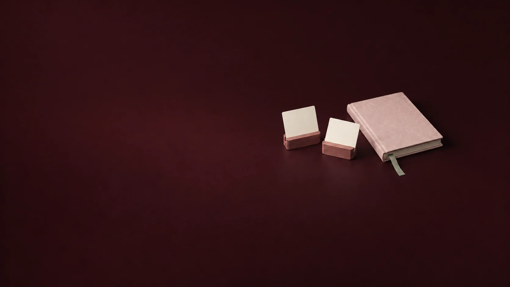 Two blank cards in rosewood holders beside a petal journal and sage bookmark. - Relationship Focused Platforms Meta ads research by Madgicx Labs
