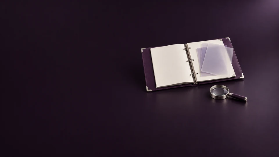 An open purple report binder with blank pages, translucent overlays and a silver magnifying glass. - Digital Marketing & Advertising Platforms Meta ads research index