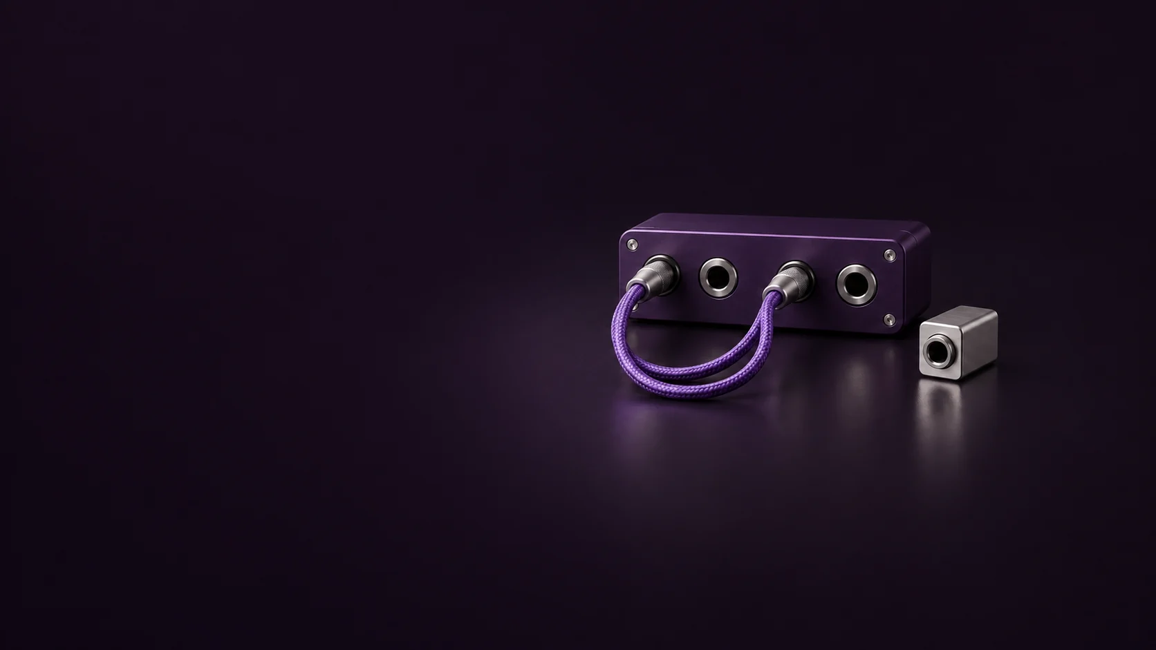 A purple desktop patch panel with a braided cable loop beside a silver adapter. - Marketing Integration Platforms Meta ads research by Madgicx Labs