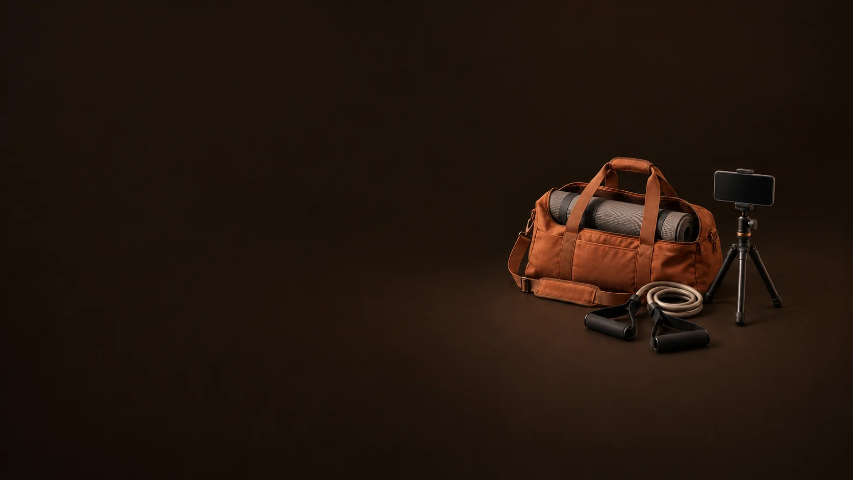 Terracotta training duffel with a rolled mat, resistance handles and an inactive phone on a small tripod. - Mobile Fitness Services Meta ads research by Madgicx Labs