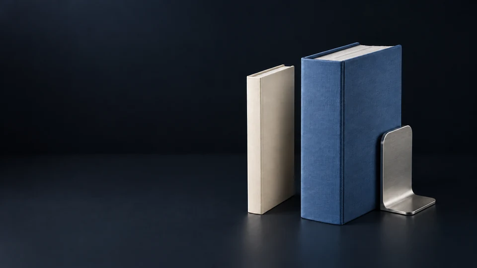 A slim ivory consultation folio beside a deep blue litigation binder and silver bookend. - Legal Services Meta ads research index