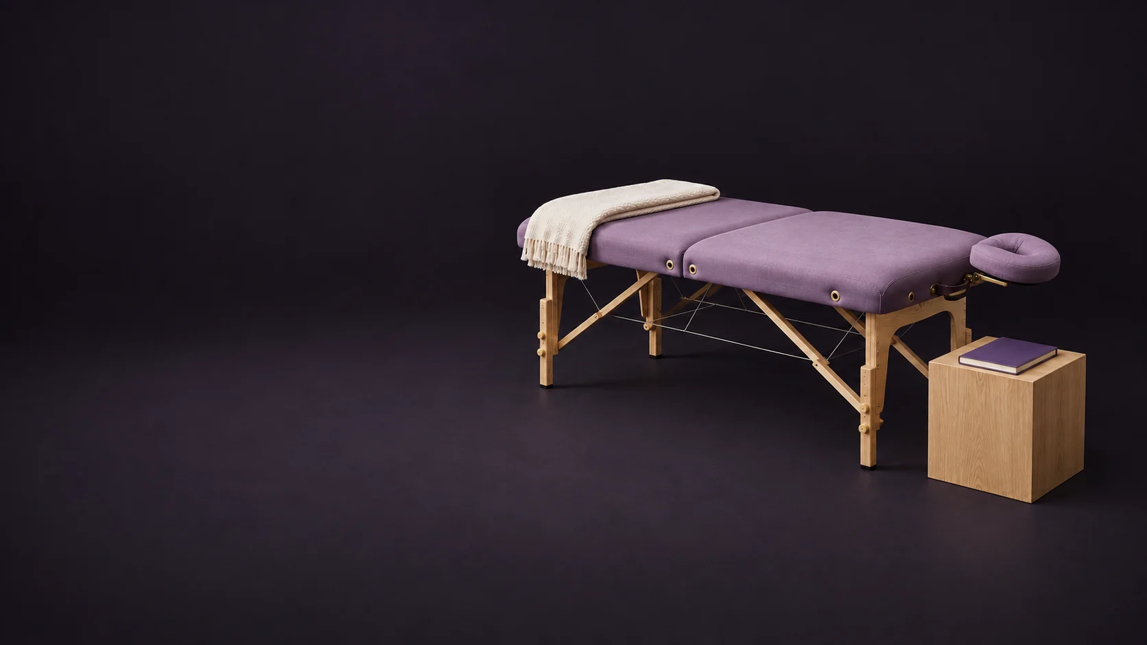 An empty mauve session table with a folded ivory blanket and a separate blank class notebook on an oak stand. - Energy Healing Services Meta ads research by Madgicx Labs