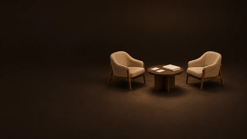 Two empty camel chairs around an oak table with paired blank cards and a closed workbook. - Personal Coaching & Development Meta ads research index